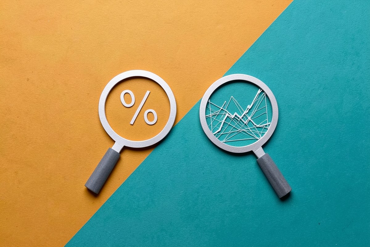 A split screen with two magnifying glasses, one over a simple percentage sign and the other over a more complex chart.